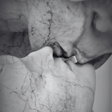 Close-up of a marble sculpture of a face with detailed texture.