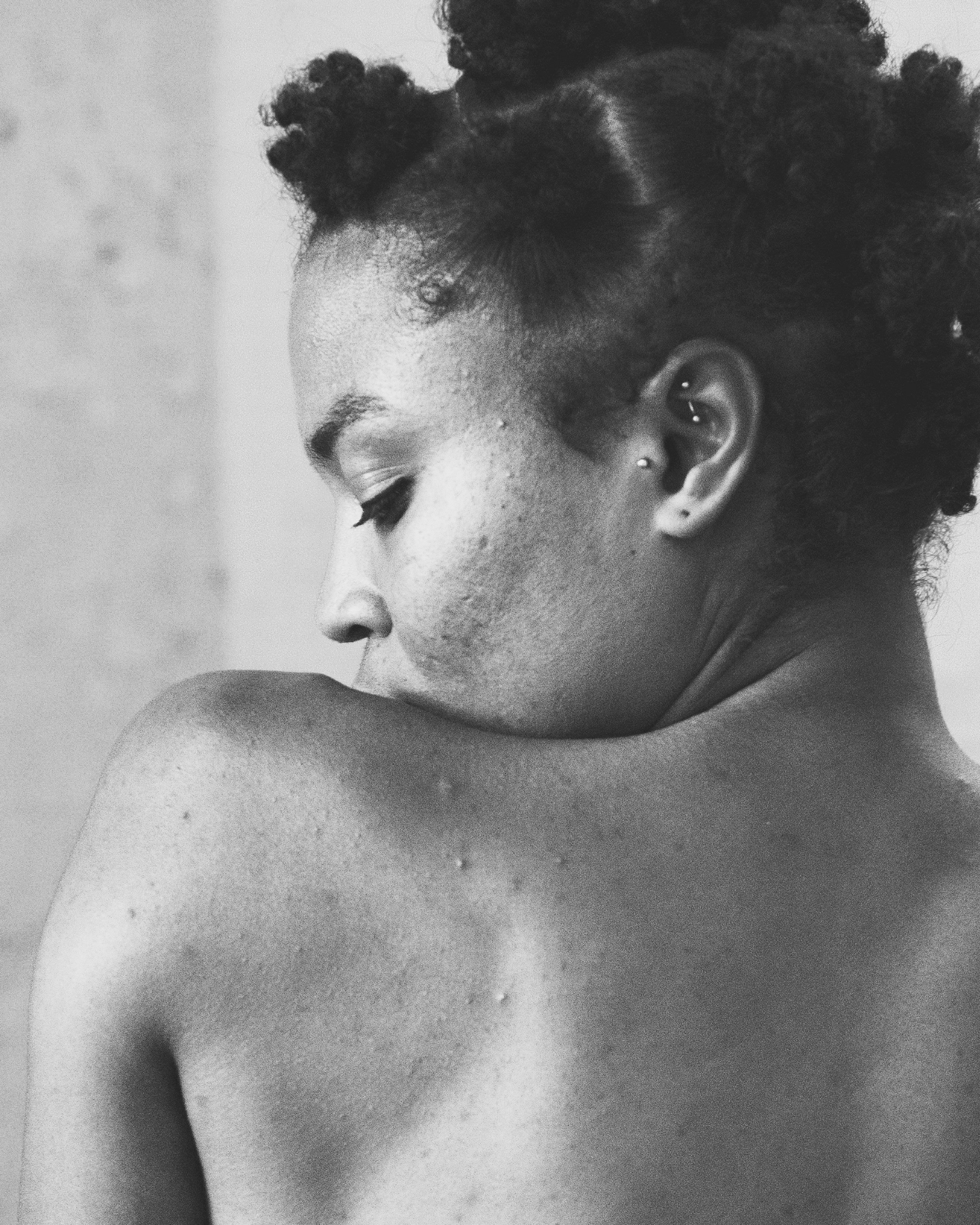 Black and white photo of a person with styled hair against a neutral background