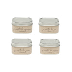 Four square metal tins with beige labels on a white background