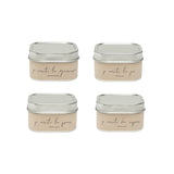 Four square metal tins with beige labels on a white background