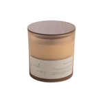 A soy wax candle in a frosted glass jar with a light wood lid and a minimalist paper label, shown on a plain white background.