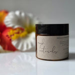 Jar of 'myd naturals' product with flowers in the background