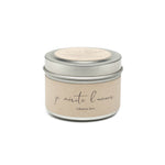 Candle in a tin with 'je mérite l'amour' text on a white background