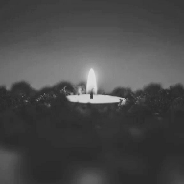 Single candle in a dark setting