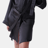 made in the softest washed silk charmeuse, this hidden button front shirt dress can be worn as a robe, pajama top or shirtdress, in and outside of the boudoir  belt loop is subtly and discretely hidden behind the back placket  complete with resting pockets  wear with a je mérite coordinating bottom or chemise  soft collar v-neck neckline subtle slits at sides removable belt sensual fit mini length  washed 100% silk charmeuse  designed and made in new york city, new york - available in 0/2-20/22