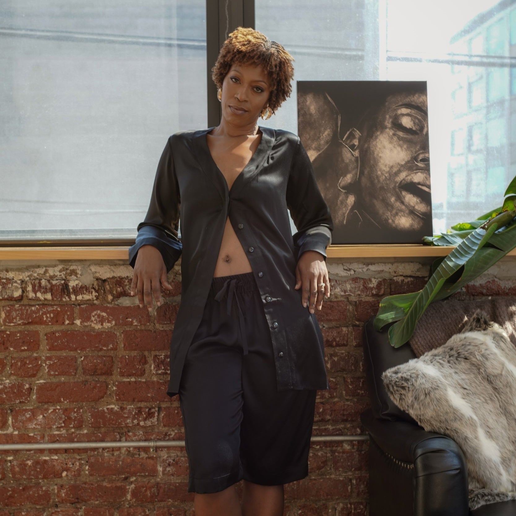 A model wearing a black silk shirtdress and bermuda shorts standing in a room with a brick wall, next to a plant and a framed portrait

made in the softest washed silk charmeuse, this bermuda short has an elastic waistband and drawstring closure  wear with a je mérite coordinating top or your favorite lingerie  wide elastic waist with drawstring closure sits at natural waist  sensual fit  washed 100% silk charmeuse  designed and made in new york city, new york - available in 0/2-20/22