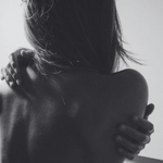 Black and white photo of a person embracing another from behind