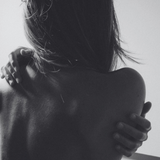 Black and white photo of a person embracing another from behind