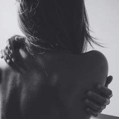 Black and white photo of a person embracing another from behind