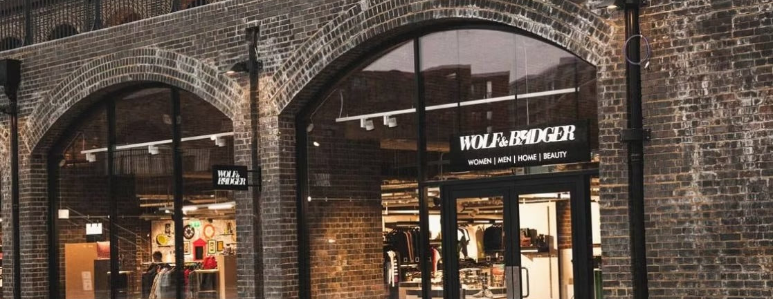 Brick building with a store entrance featuring the Wolf & Badger brand.