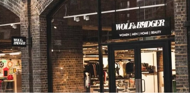 Brick building with a store entrance featuring the Wolf & Badger brand.